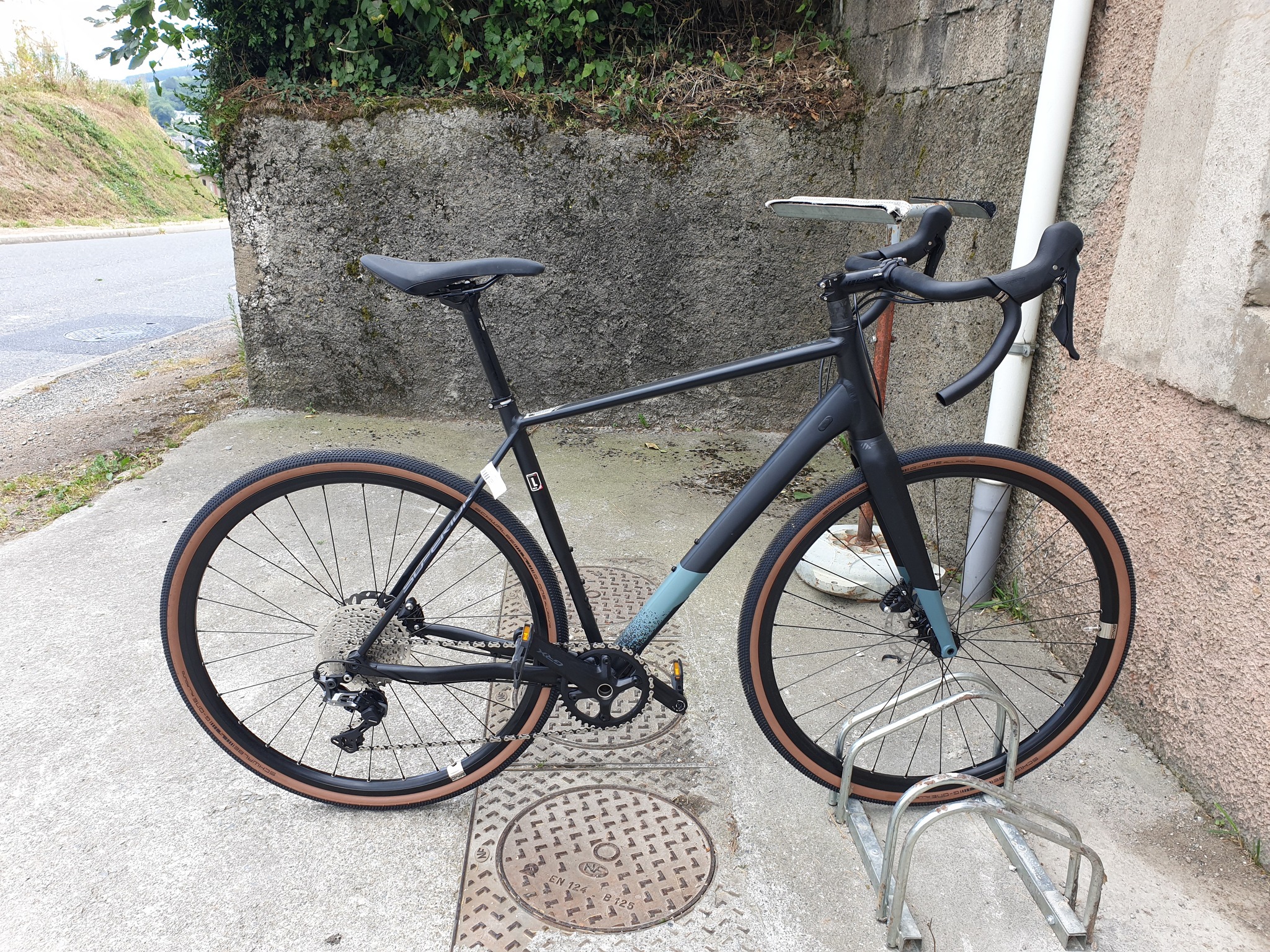Vélo route Bicicleta-Maurandy posé sur un support à lacaune-alban-brassac-81230 devant un mur de pierre,
