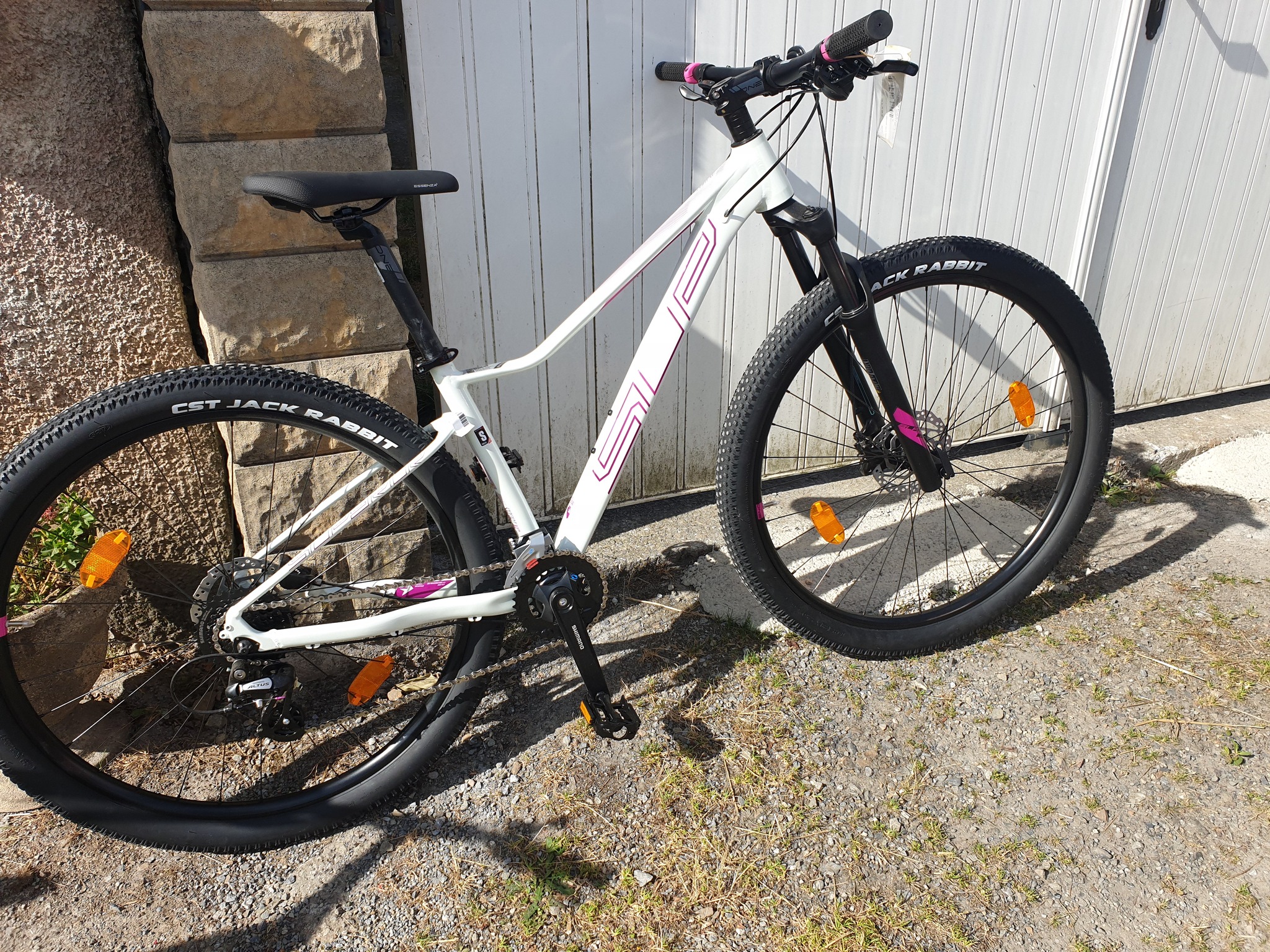 VTT blanc sportif Bicicleta-Maurandy devant mur en pierre à lacaune-alban-brassac-81230, pneus crantés CST,