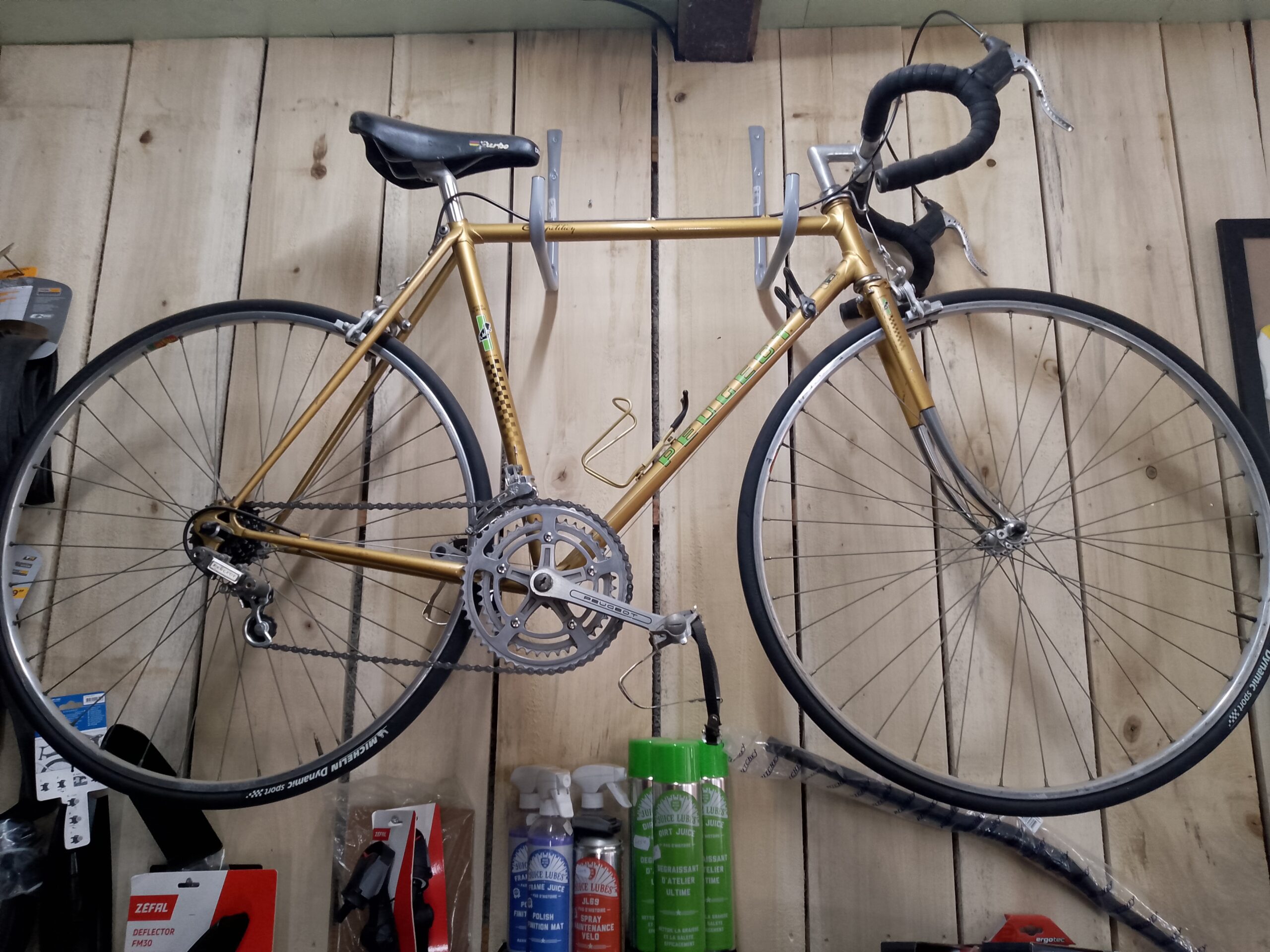 Vélo de course doré chez Bicicleta-Maurandy à lacaune-alban-brassac-81230, atelier avec équipements cyclisme,